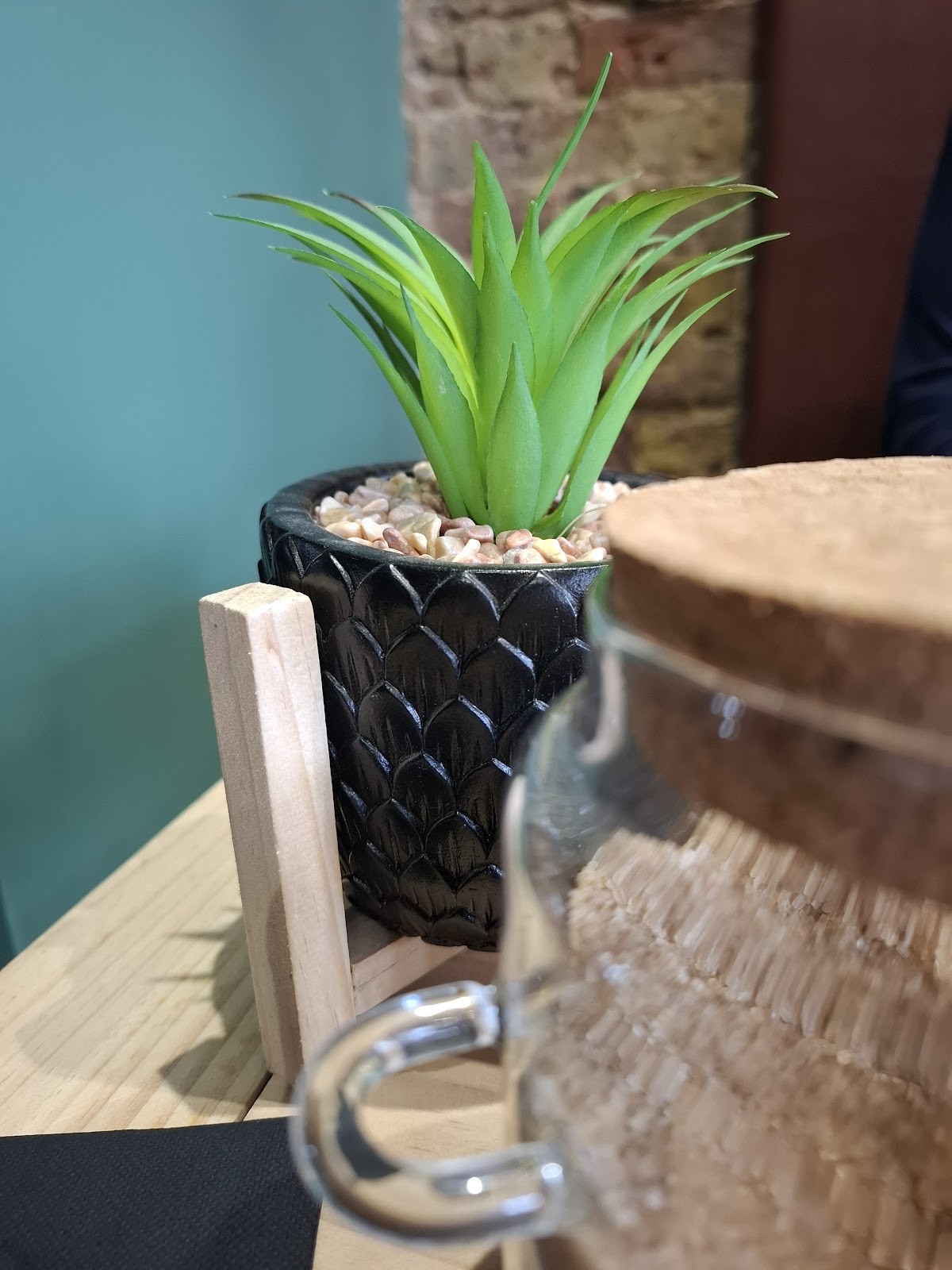 A potted succulent and glass jar on the counter edge